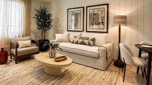 Sala de estar com sofá, poltronas, mesa de centro e luminária de chão.
