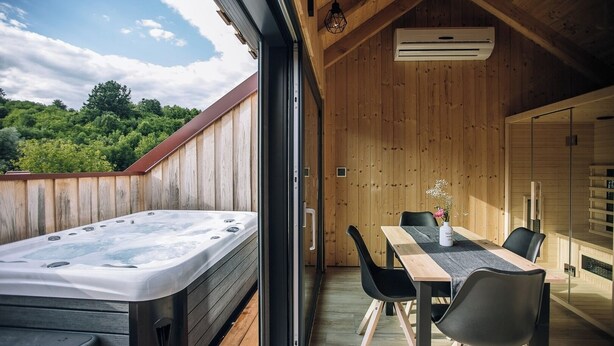 A wooden interior with a hot tub, a dining area, and a view of the outdoors. - Lavender Retreat | With Jacuzzi and Sauna (Kamnica)