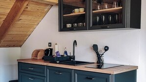 A kitchen with dark cabinets, a wooden countertop, and a built-in shelf above the sink. - Lavender Retreat | With Jacuzzi and Sauna (Kamnica)