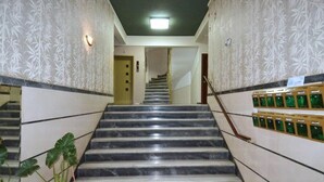 A marble staircase leading to a landing with a door at the top.
