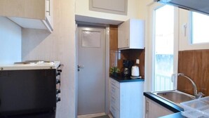 A compact kitchen with a microwave, coffee maker, and sink.