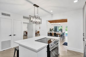A modern kitchen with a central island, built-in oven, and pendant lighting. - Waterfront Fun! 6BR • Pool • Beach 5 Min (Hollywood)
