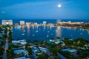 A coastal cityscape with a marina, buildings, and a clear night sky. - Waterfront Fun! 6BR • Pool • Beach 5 Min (Hollywood)