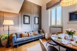 A modern living room with a sofa, dining table, and artwork on the walls. - Experience an Unparalleled Blend of Style and Comfort, Just Steps from the Sea. (Viareggio)