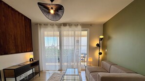 Een woonkamer met een bank, een salontafel, een tv-meubel en een vloerlamp.