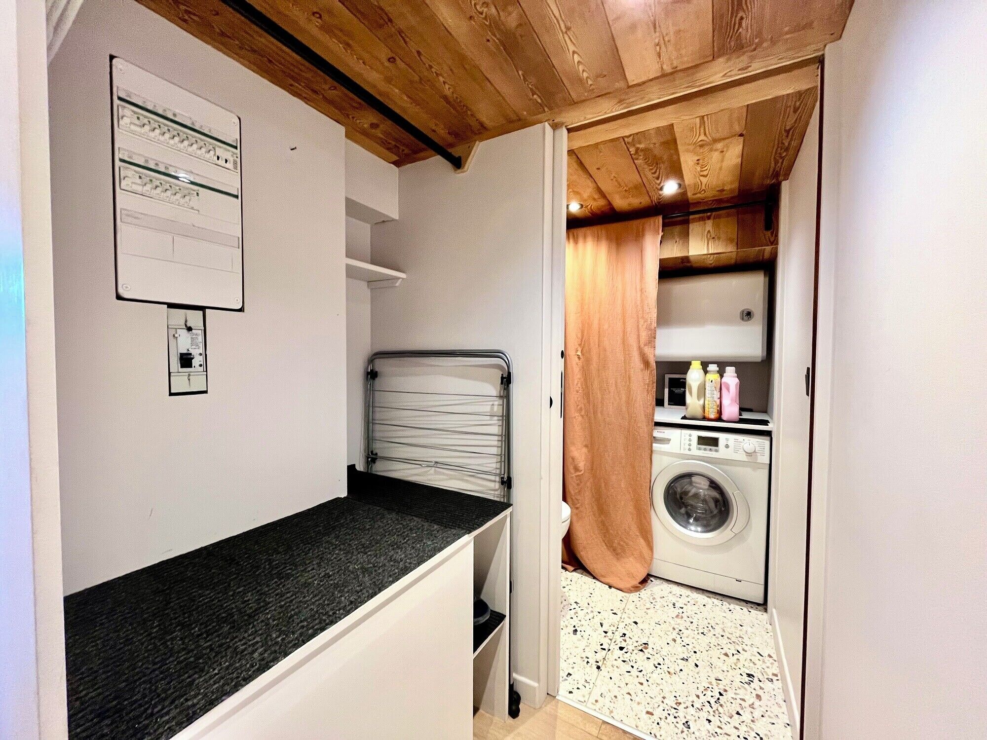 A compact kitchen with a countertop, a washing machine, and a small sink.