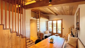 A wooden staircase leading to a loft bedroom with a view of the outdoors. - Charming studio with mountain view & balcony (Combloux)
