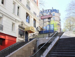 Un escalier menant à un immeuble sur lequel on peut lire l’inscription « MÉTROPOLITAIN ».