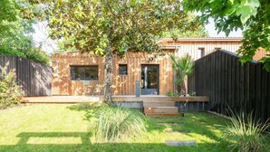 Ein Holzhaus mit Veranda, einem kleinen Garten und einem Holzzaun.