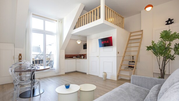 Eine moderne Lofts-Wohnung mit Küche, Essbereich und Wohnzimmer.