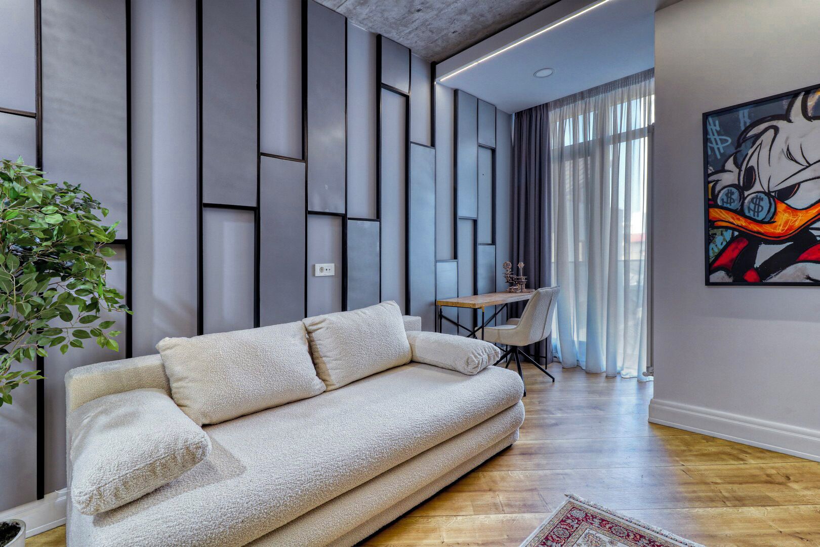 A modern living room with a sofa, a dining table, and a plant.