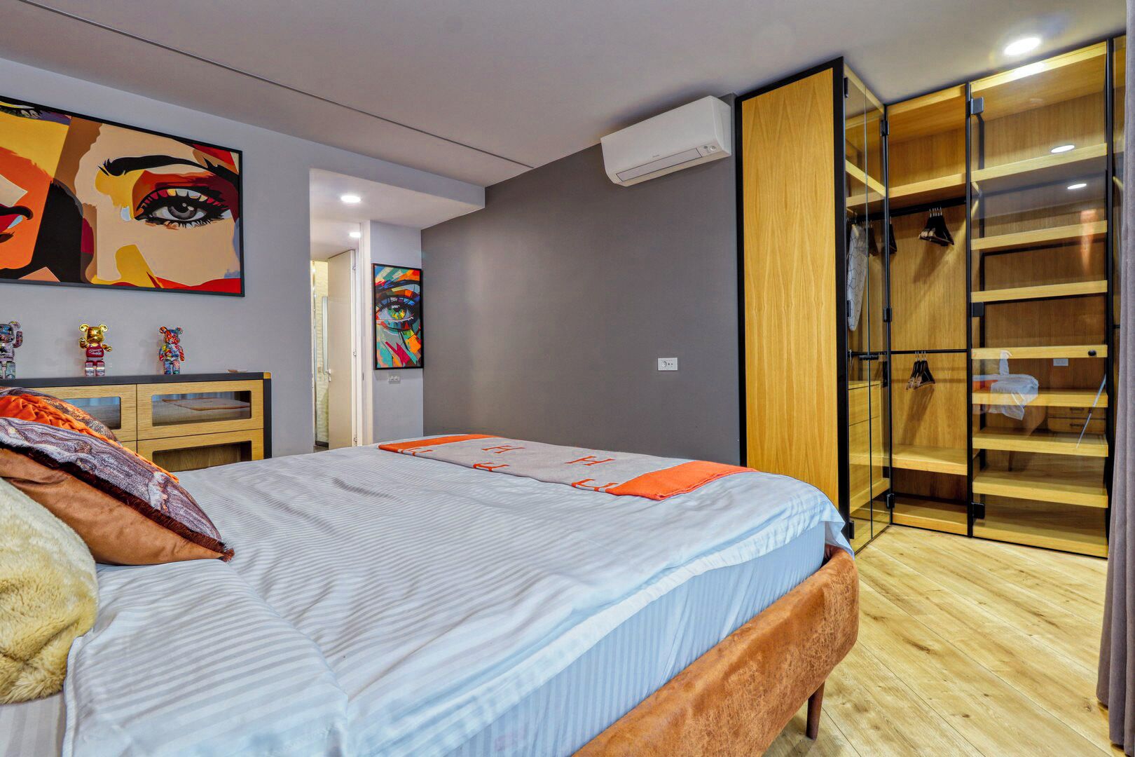 Ein modernes Schlafzimmer mit Bett, Kleiderschrank und einem Bild an der Wand.