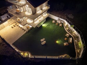 A multi-level building with outdoor seating and a pool.