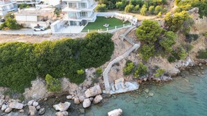 Ein Küstenanwesen mit einem großen Haus, einem privaten Garten und einer felsigen Küstenlinie.