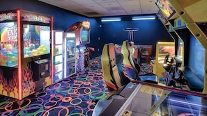 Eine Spielhalle mit verschiedenen Spielautomaten, darunter Greifarme und Rennsimulationen.