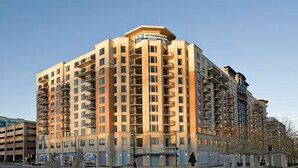 Un hôtel à plusieurs étages, reconnaissable à son grand panneau « WYNDHAM », doté de balcons à chaque étage et présentant une architecture d’angle distinctive.
