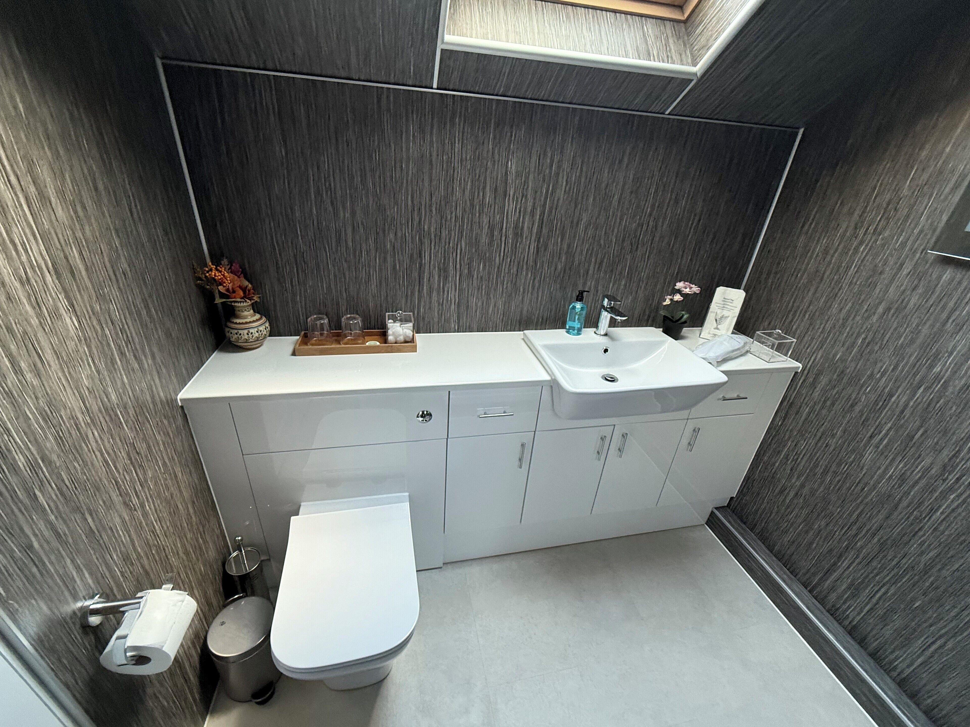 A modern bathroom with a white sink, toilet, and vanity.