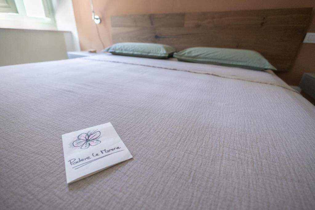 A neatly made bed with a pillow and a card on it.