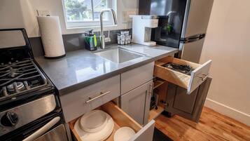 Une cuisine équipée d’une cuisinière, d’un évier et d’un réfrigérateur.