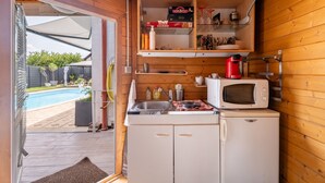 A compact kitchen with a microwave, sink, and storage shelves. - Bed and Breakfast 'Béatrice - Bijou' with Shared Pool, Shared Terrace and Wi-Fi (Hochfelden)