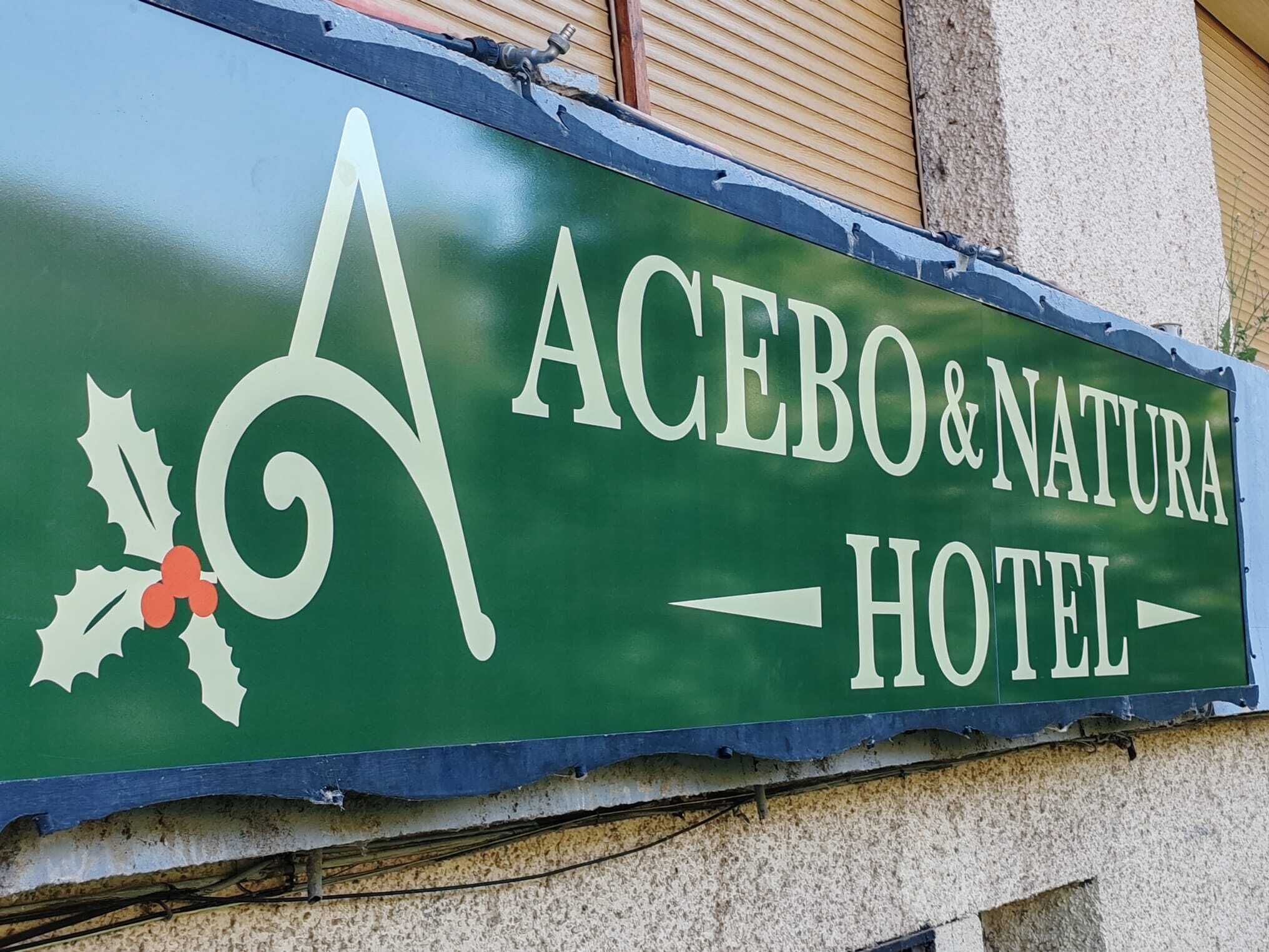 Groen bordje voor Acebo & Natura Hotel met gestileerd logo en een richtpijl.