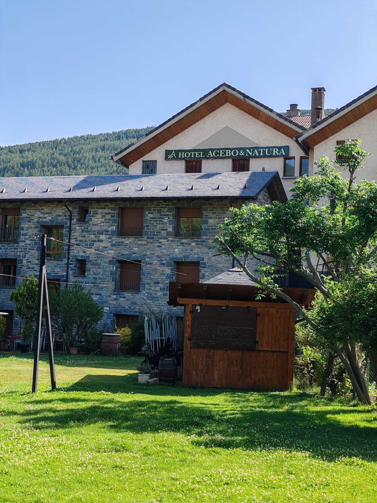 Un edificio de piedra con un cartel que dice 'Hotel Acebo & Natura'.