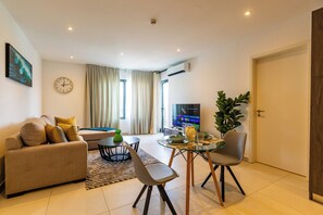 Apartamento conforto, 1 cama Queen, sacada, vista para a cidade | Área de estar