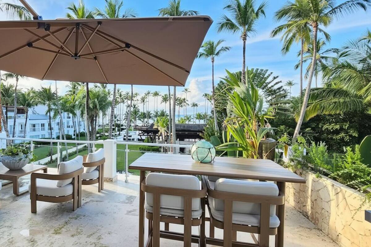 A patio with outdoor furniture, a table, and a large umbrella.