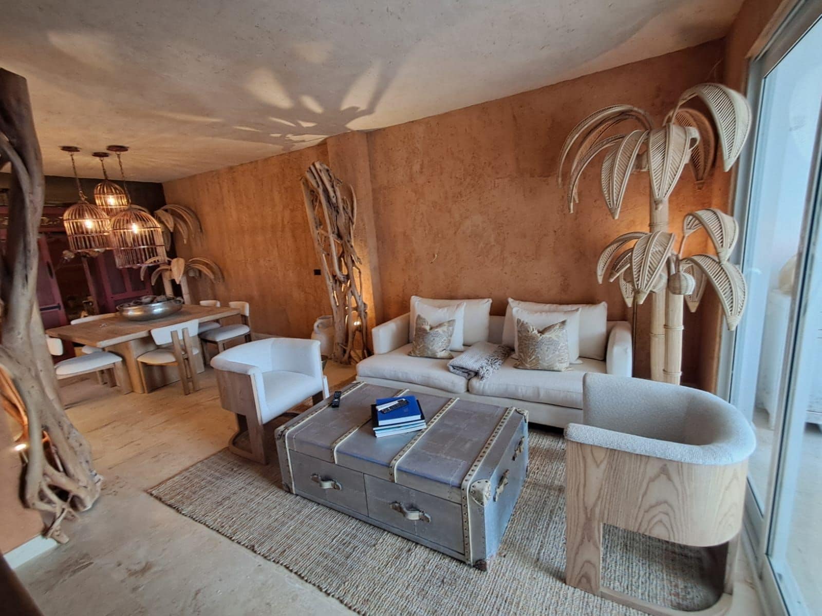A modern living room with a sofa, coffee table, and a dining area with a table and chairs.