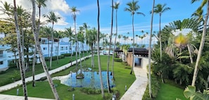 A resort with a pool, palm trees, and a clear sky. - MŪTE AT COSON BAY HOTEL AND RESIDENCES (Las Terrenas)