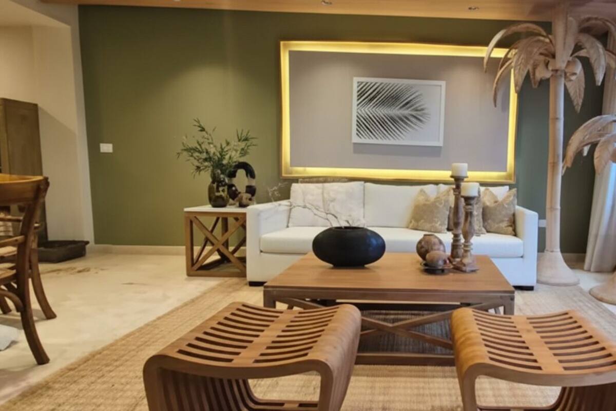 A modern living room with a sofa, coffee table, and two wooden chairs.