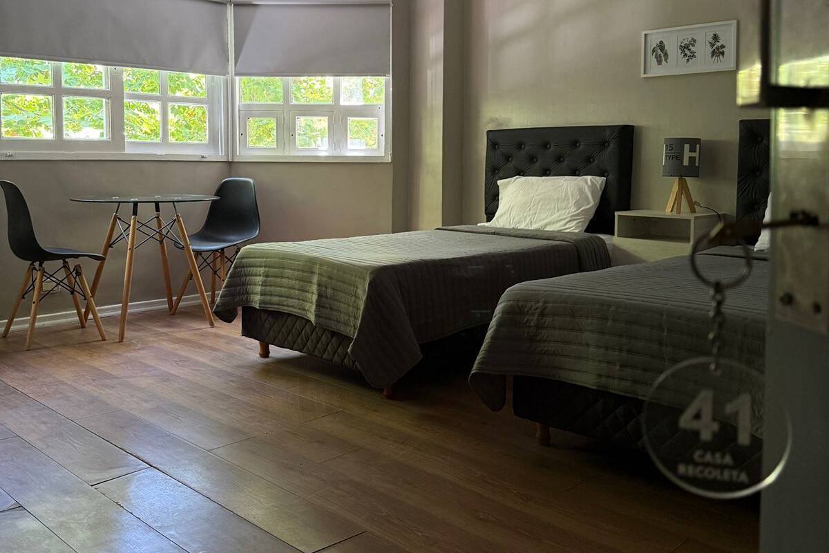 Une chambre avec deux lits, un bureau et une chaise.