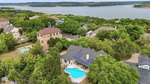 Un barrio residencial con casas, una piscina y un lago al fondo.