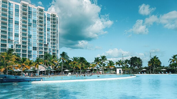 A hotel with a large pool, palm trees, and a clear sky. - Playa Blanca Signature (Rio Hato)