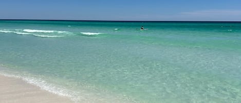 A beach with clear turquoise water and a sandy shore.