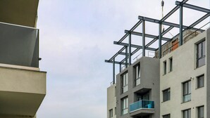 A multi-story residential building with balconies, a view of the cityscape, and a parking area. - Soothing 1-bedroom apartment in Floreasca, București (București)