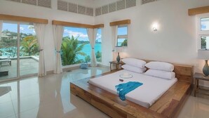 Un dormitorio espacioso con una cama grande, vistas al océano y un balcón.