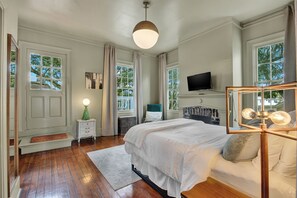A bedroom with a bed, a television, a window, and a door. - The Treehouse Walk to Forsyth, Balcony (Savannah)