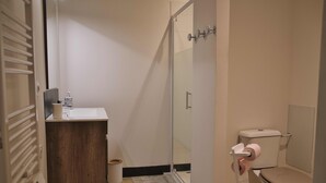 A bathroom with a toilet, sink, and shower. - Studio Apartment 'Centre Historique Beaucaire' with Wi-Fi (Beaucaire)