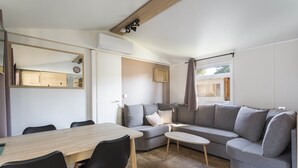Una sala de estar moderna con un sofá, una mesa de comedor y sillas.