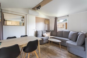 Un salon moderne avec un canapé, une table à manger et des chaises.