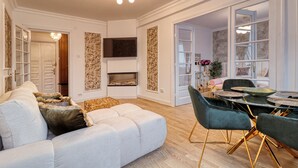 A modern living room with a sofa, chairs, a fireplace, and a dining area. - Cozy 1-bedroom apartment in the City Center in București (București)