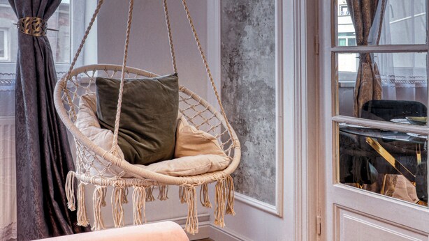 A room with a hanging chair, a large window with curtains, and a door with a view of the street. - Cozy 1-bedroom apartment in the City Center in București (București)