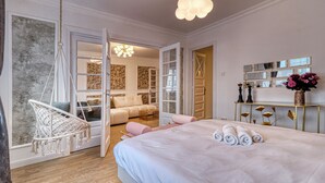 A bedroom with a bed, a hanging chair, a sofa, and a mirror on the wall. - Cozy 1-bedroom apartment in the City Center in București (București)