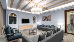 A modern living room with a sofa set, a television, and a chandelier. - The Mirage VIP At Habtoor polo Resort  (Dubai)