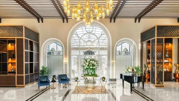 A spacious lobby with a grand chandelier, a piano, and a central floral arrangement. - The Mirage VIP At Habtoor polo Resort  (Dubai)
