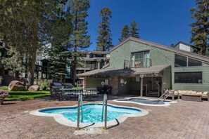 A pool area with a hot tub, outdoor seating, and a building with a balcony. - Alpine Escape, Cool Pool-Spa, Lakes & Trails Galore, Near Fine Dining / Bars (Mammoth Lakes)