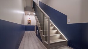 A modern staircase with a wooden finish and a handrail, leading to an upper floor. - Hotel Beebop (Toronto)