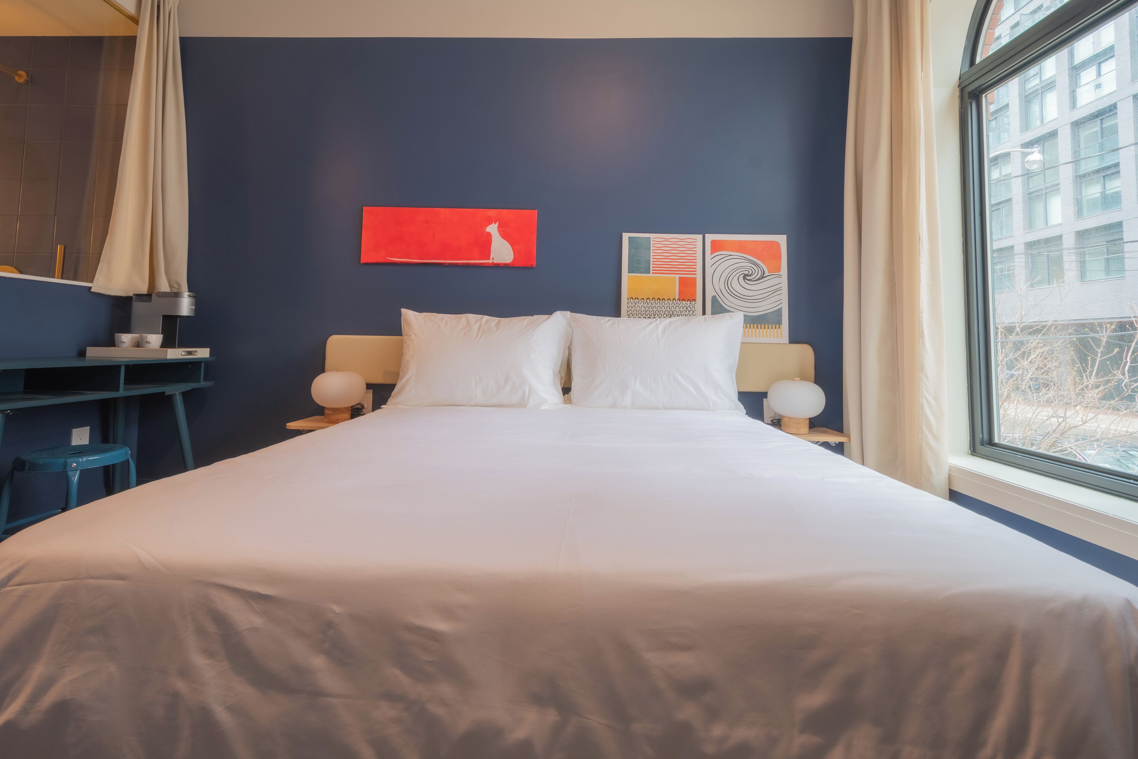 A hotel room with a bed, two bedside tables, a desk, and a chair.