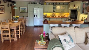 A cozy kitchen with a dining area, wooden furniture, and a sign reading 'Carrot Farmhouse.' - Countryside Farmhouse - Glasgow - Sleeps 6 (Eaglesham)